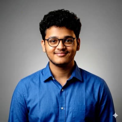 Portrait of Somanadh K wearing glasses and a blue shirt.